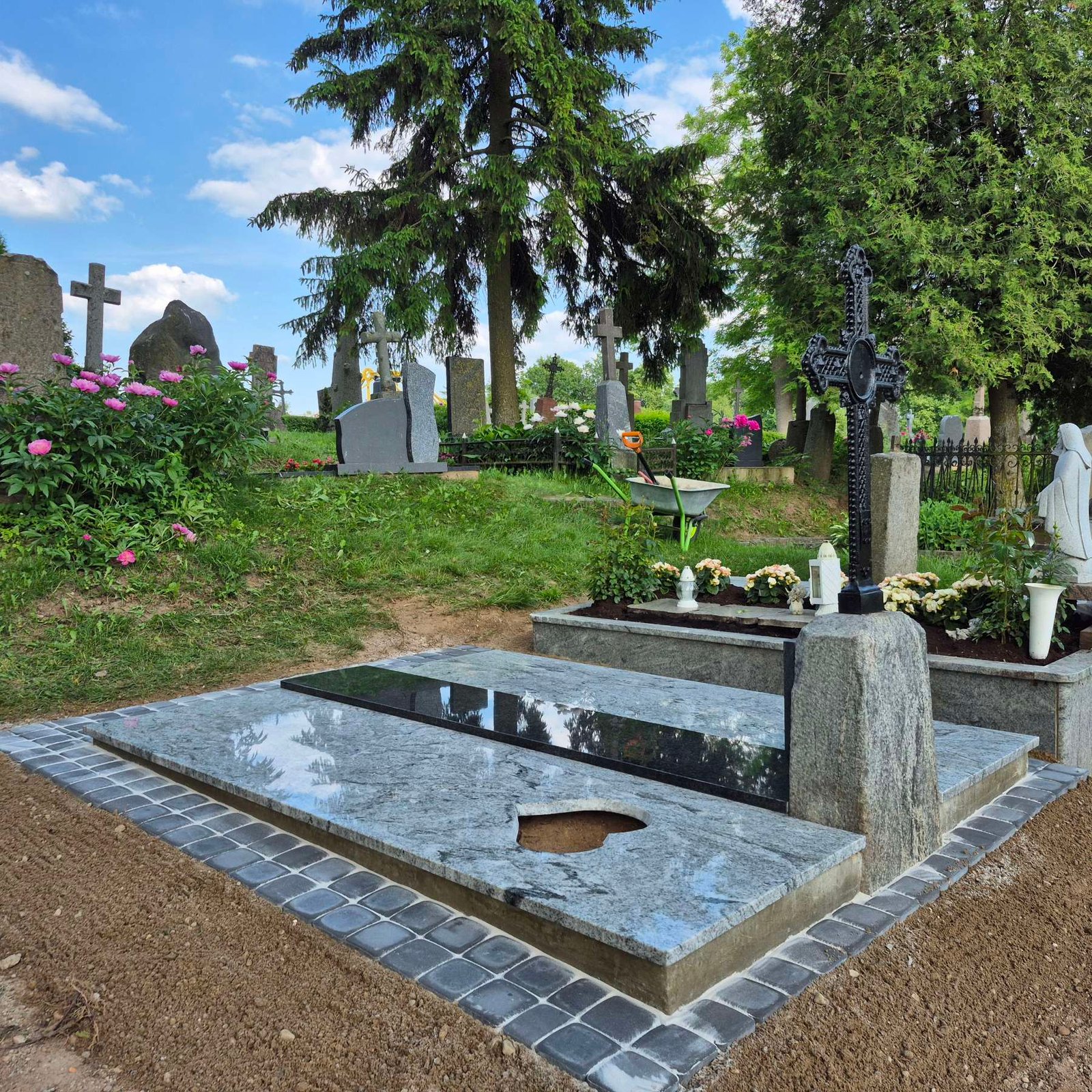 Kapavietė su širdies formos elementu tarp gėlių